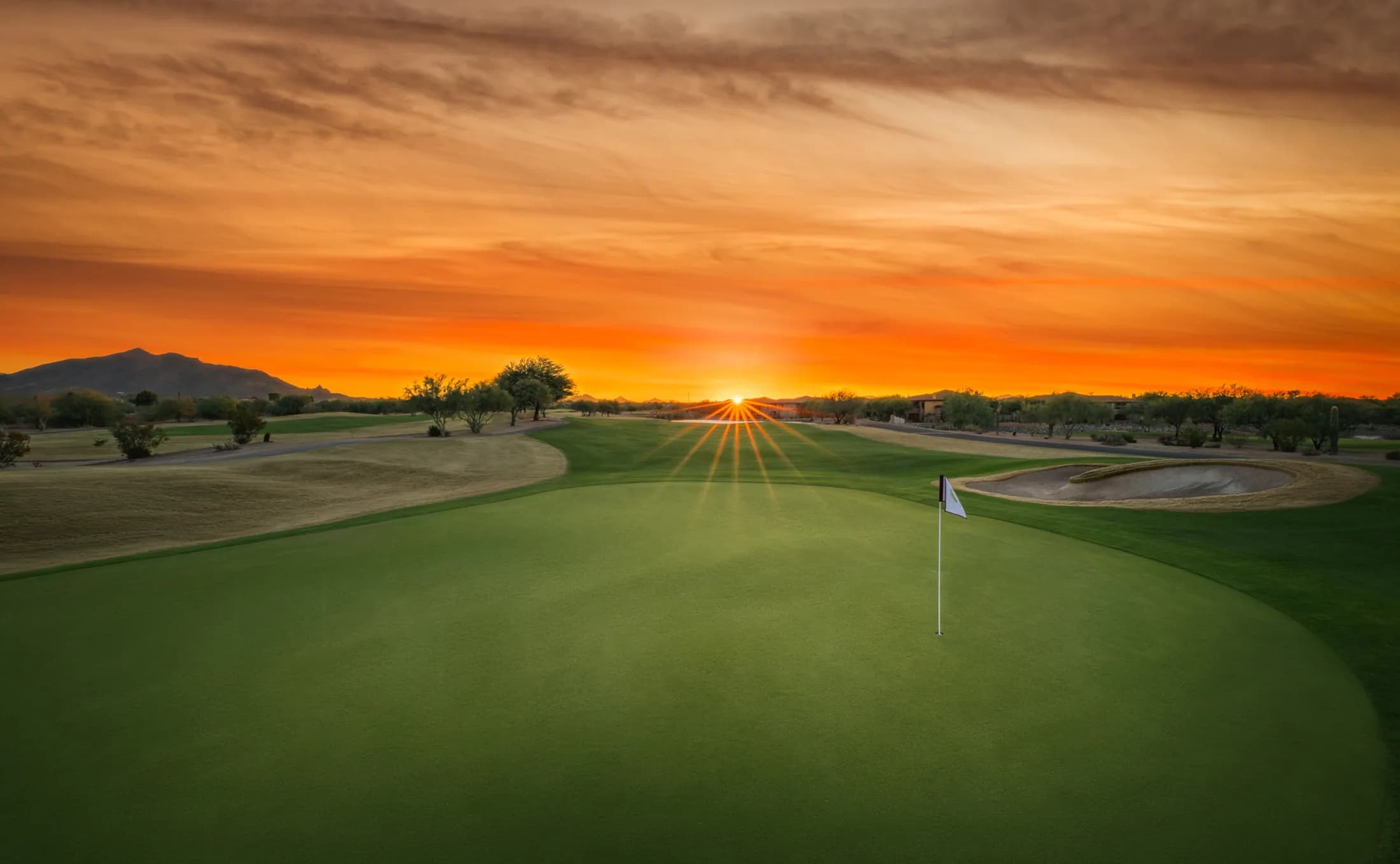 Dove Valley Ranch course green with orange sunset in the background.