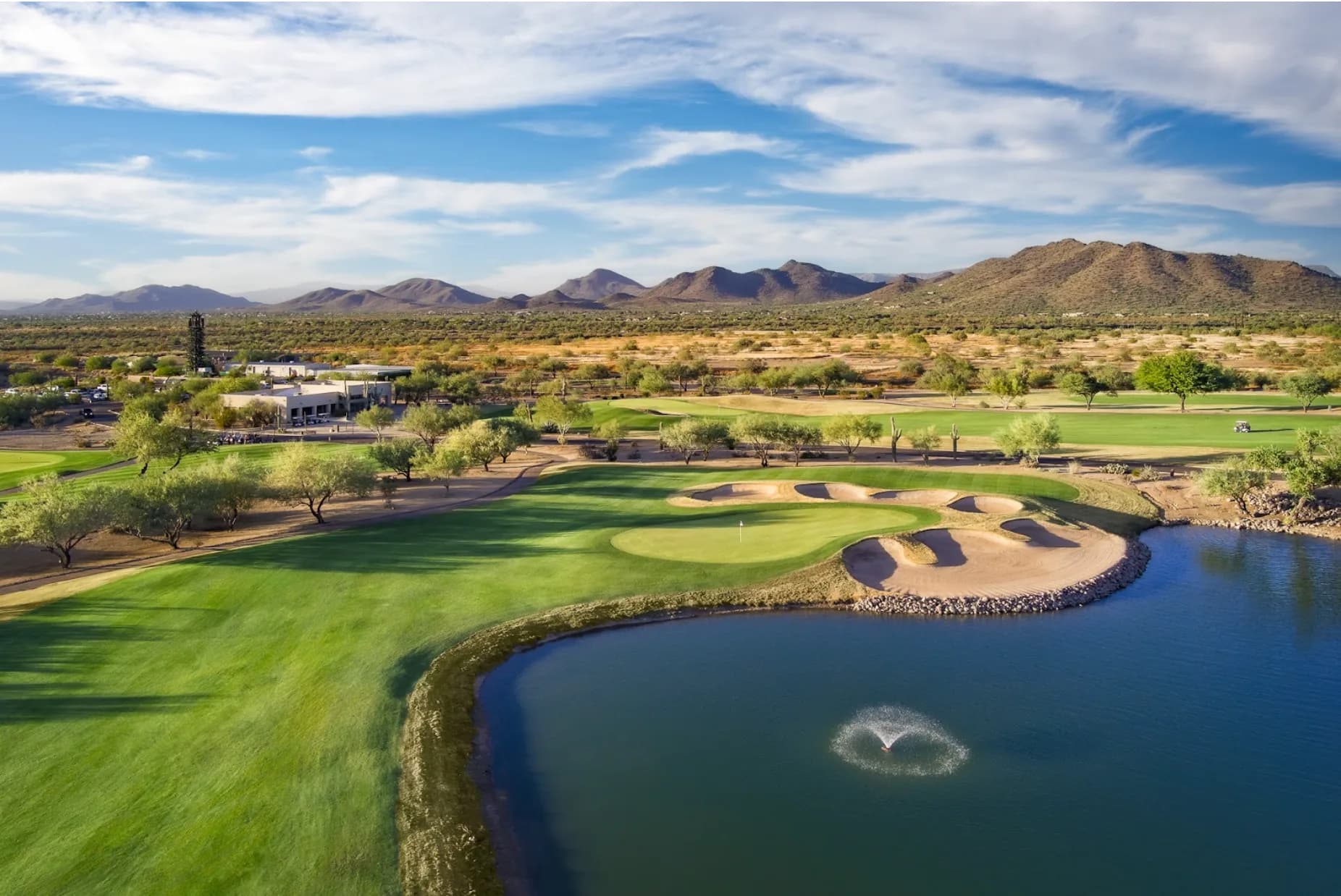 Dove Valley Golf Club greens with desert flora and a mountain range in the background.