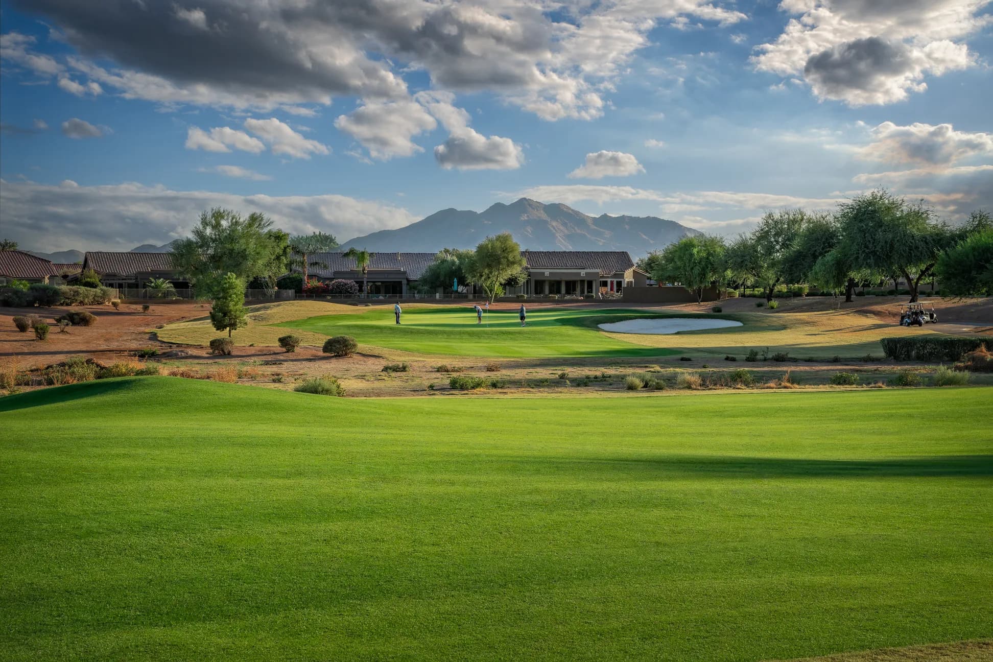 The 14th at Power Ranch Golf Club, with the clubhouse and mountains beyond